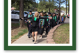 graduates walking down sidewalk