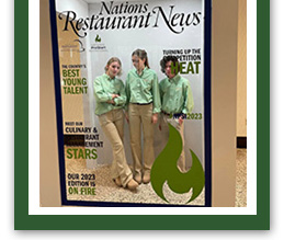 three students on a magazine display of Nations Restaurant News