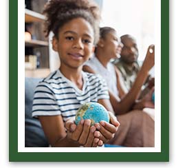 Elementary student holding up a globe