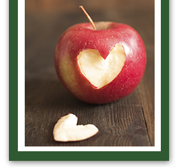 Red apple with a heart-shaped bite taken out of it