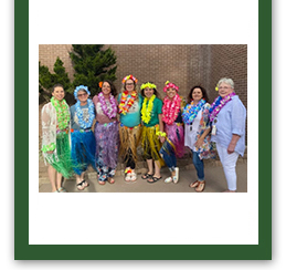 Group of staff members posing for a picture outside